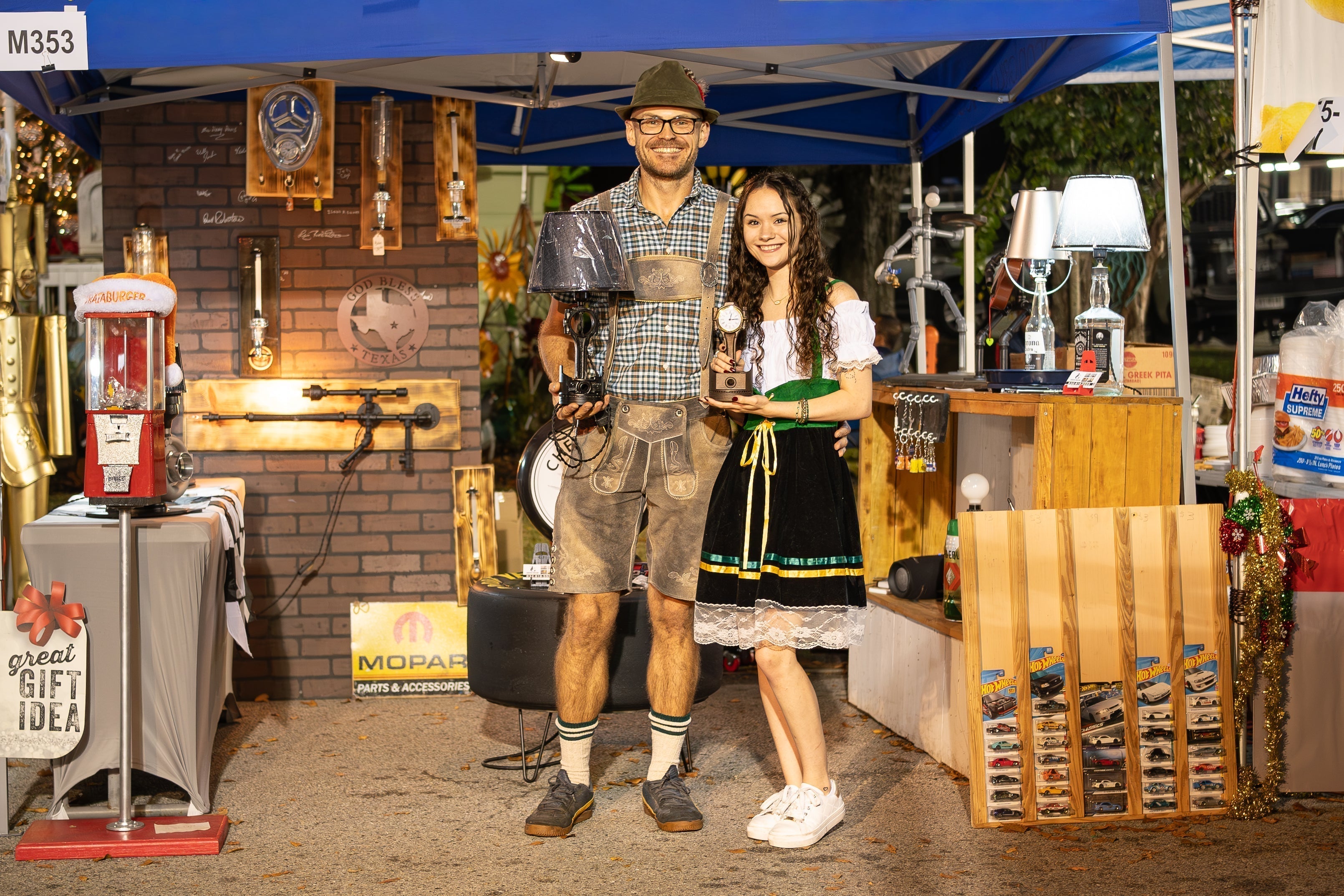 3G Unique Decor family at their booth during the Tomball German Christmas Festival, showcasing handcrafted automotive-inspired lamps and décor.