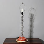 Table lamp with unique design on a wooden surface against a gray wall