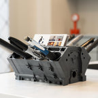Black office supply organizer with stationery items on a desk
