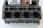 Gray metal engine block mold with 'Unique Decor' branding on a white background