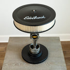 Edelbrock air filter on a wooden surface with a white background