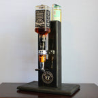 Whiskey decanter with three bottles on a wooden stand against a white background