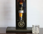 Black Daniel's whiskey decanter with a glass on a wooden surface