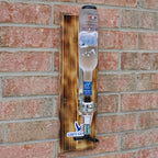 Wooden bottle holder with a bottle against a brick wall