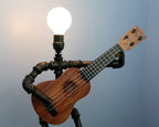Ukulele lamp with a light bulb on a plain background