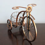 Decorative bronze bicycle with a basket on a reflective surface