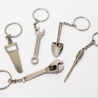 Set of metal keychains shaped like tools on a white background