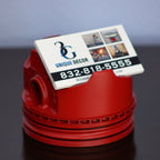 Red decorative item with a business card on a dark surface