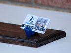 Business card holder with a business card on a wooden surface