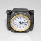 Mechanical-style clock with a gold rim and Roman numeral markers on a gray background