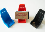 Three car seat models in blue, red, and black with a business card holder in the center.