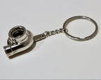Metal keychain shaped like a turbocharger on a white background
