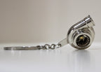 Turbocharger keychain on a white surface with a neutral background