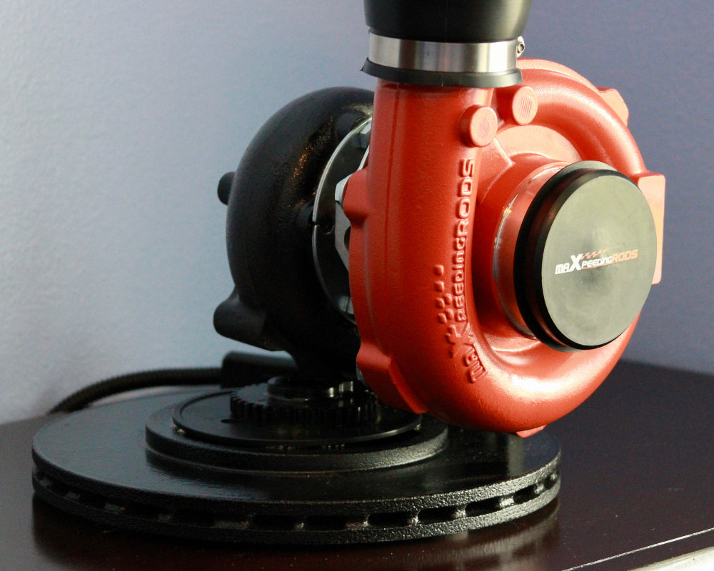 Red and black sander on a dark surface with a light blue wall background