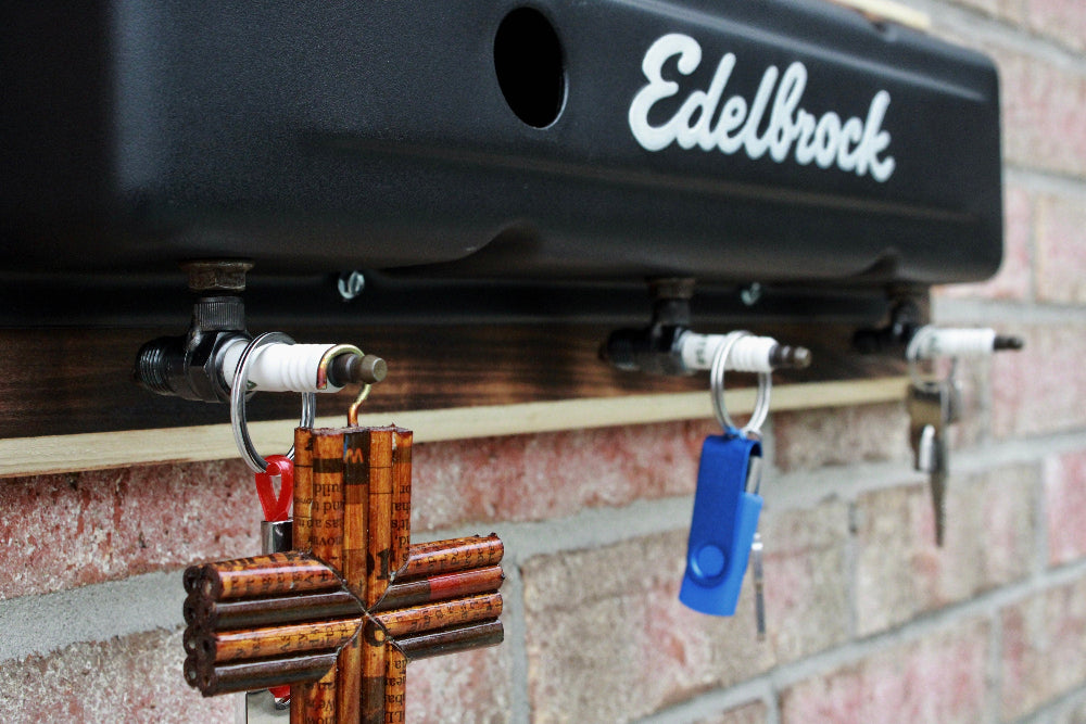 Edelbrock automotive part attached to a vehicle with decorative items hanging below.