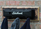 Edelbrock exhaust system mounted on a brick wall