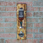Wooden bottle opener with Jack Daniel's design mounted on a brick wall