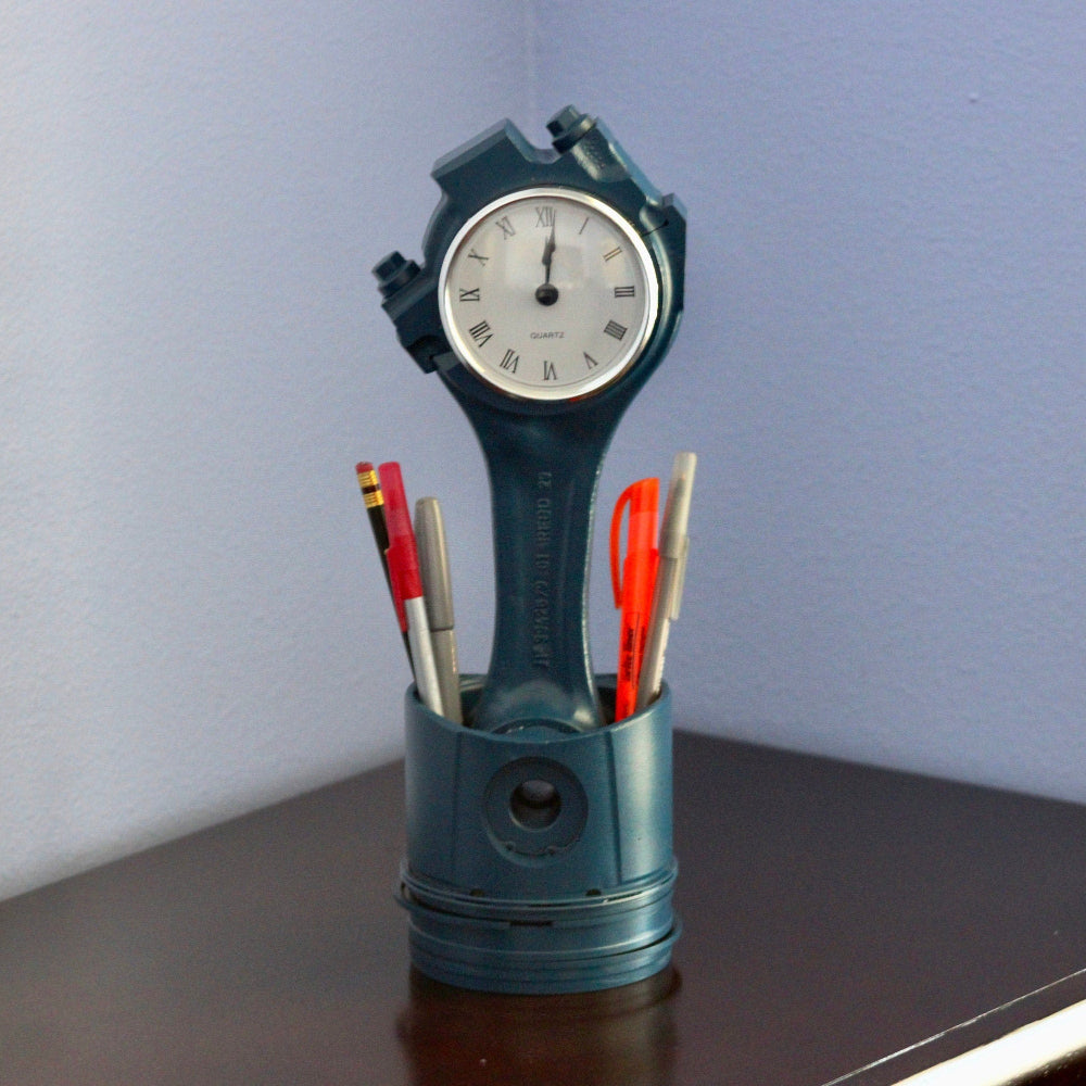 Car part clock with piston body designed to store pens tools and small items while displaying time.