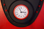 Clock with red frame and black face on a red background