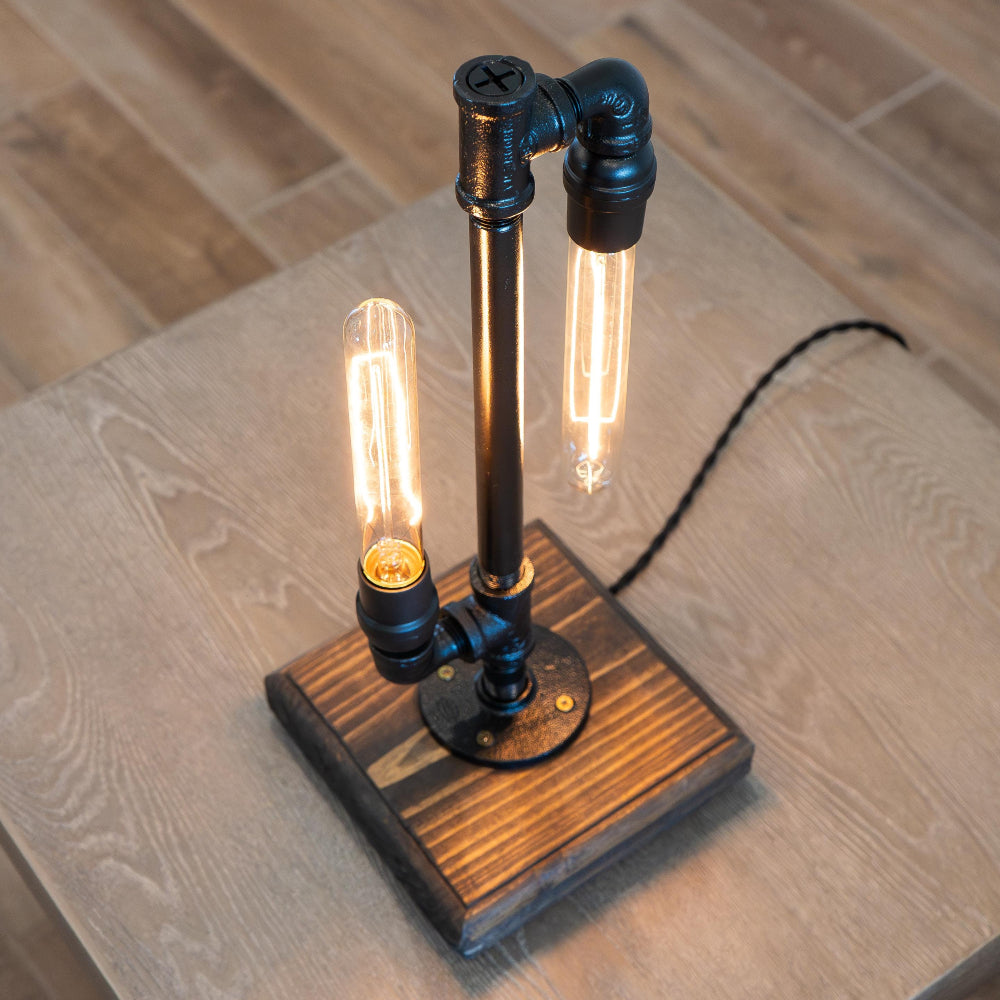 Pipe lamp featuring an Edison style bulb that creates warm ambient lighting for living spaces.