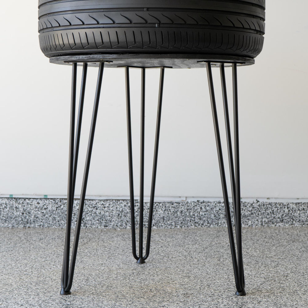 Handcrafted bar height tire table built from a real tire, offering durable construction and bold automotive decor appeal.