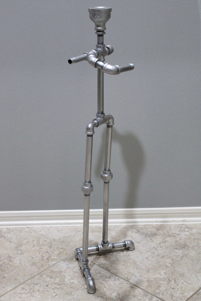Metal toilet paper storage stand with top shelf for small items.