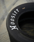 Motorsports tire coffee table made from a retired Hoosier racing tire, designed for automotive-themed living spaces.
