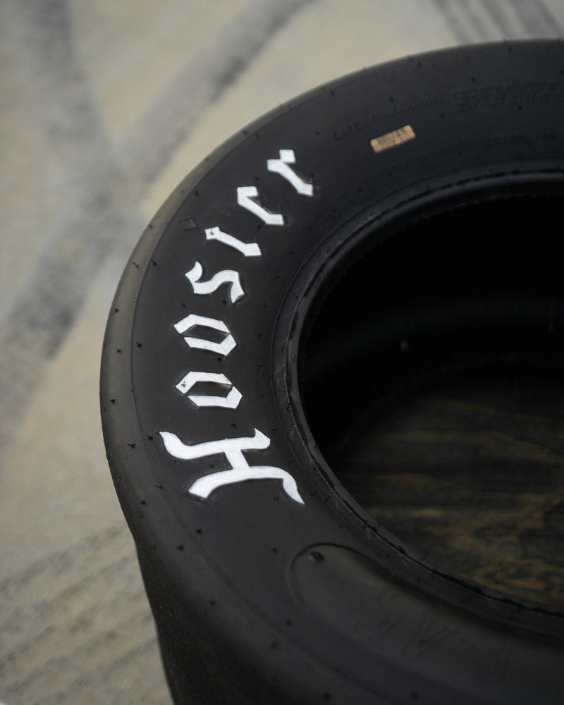 Motorsports tire coffee table made from a retired Hoosier racing tire, designed for automotive-themed living spaces.