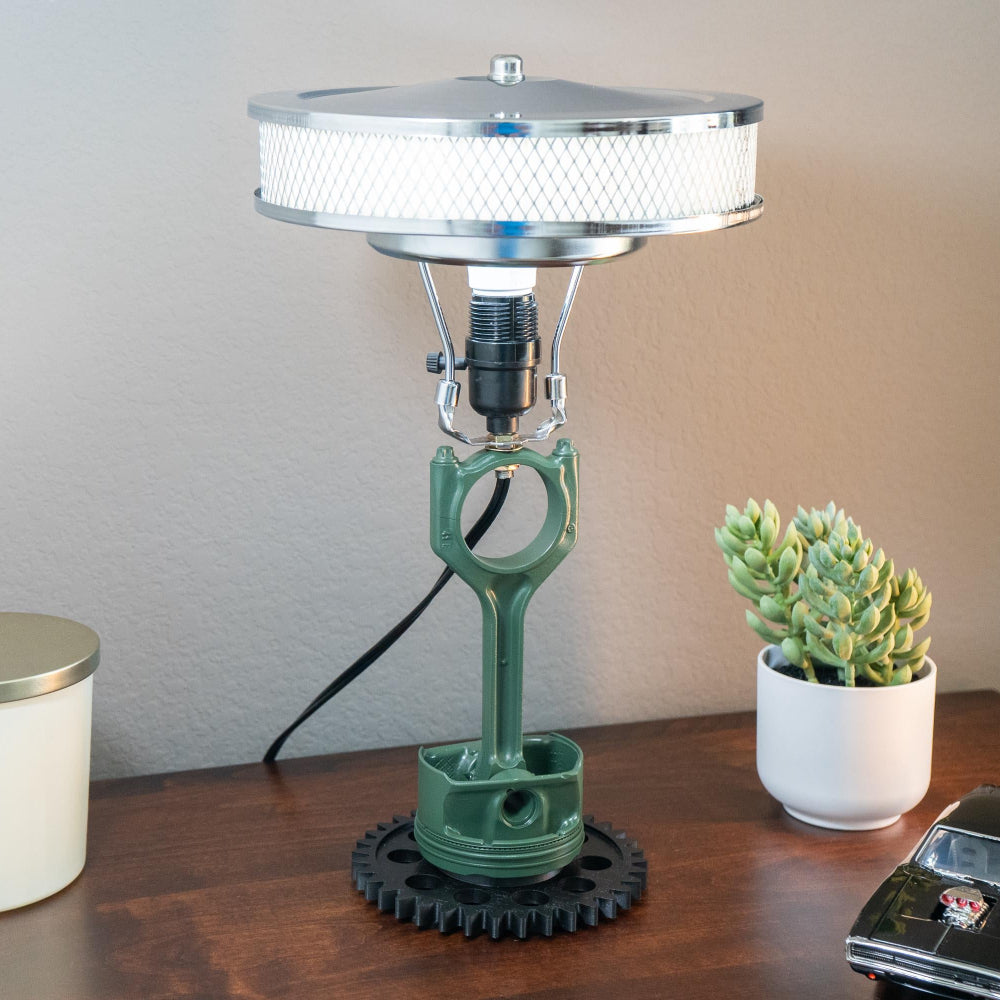 Piston lamp supported by a precision gear base modeled after real mechanical components.