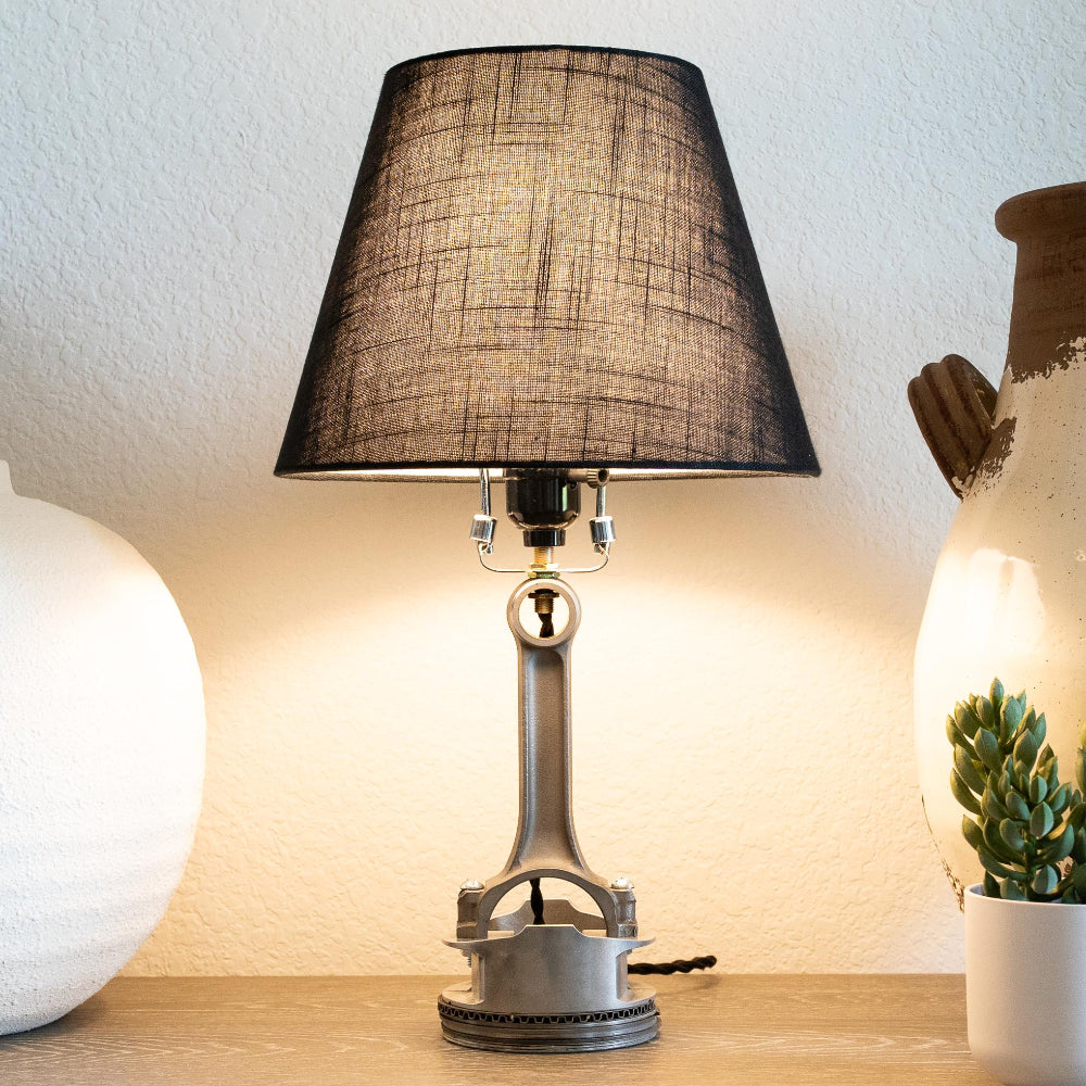 Piston table lamp made from a repurposed engine piston, designed as modern sculptural lighting with subtle automotive character.