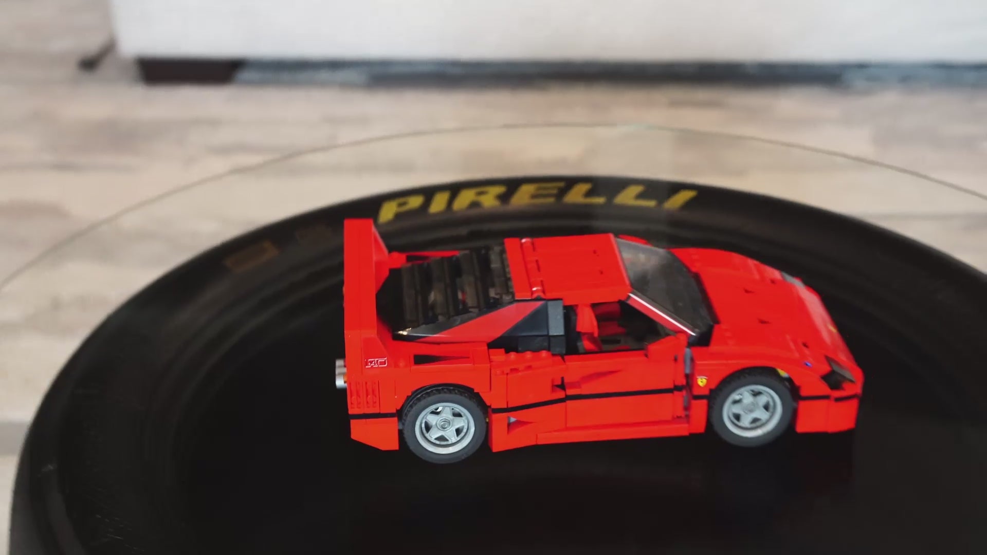 3G Unique Decor handcrafted Pirelli racing tire coffee table with round glass top displaying a red Ferrari model car.