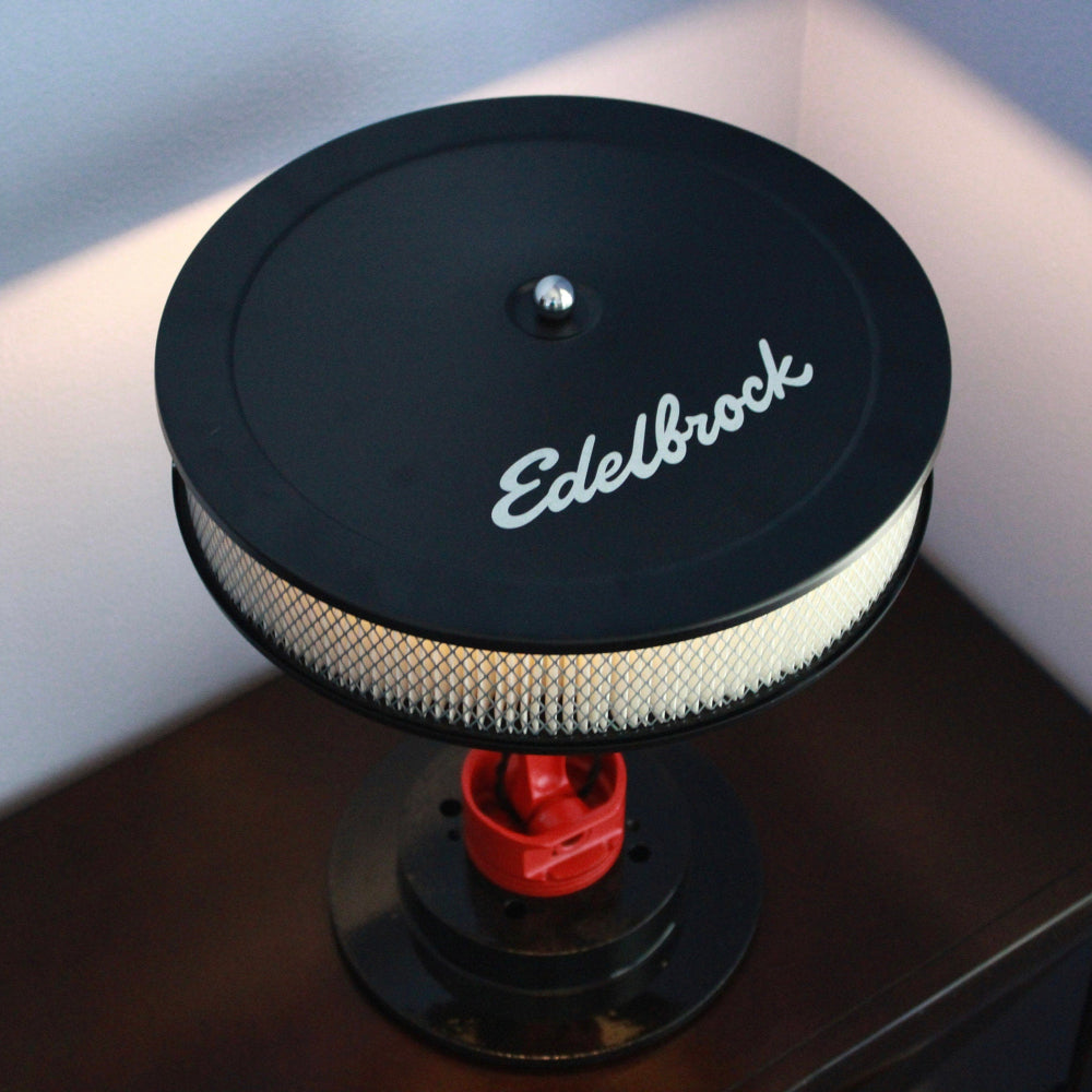 Desk lamp made from real car parts, combining a metal piston and rotor with functional lighting for automotive-themed interiors.