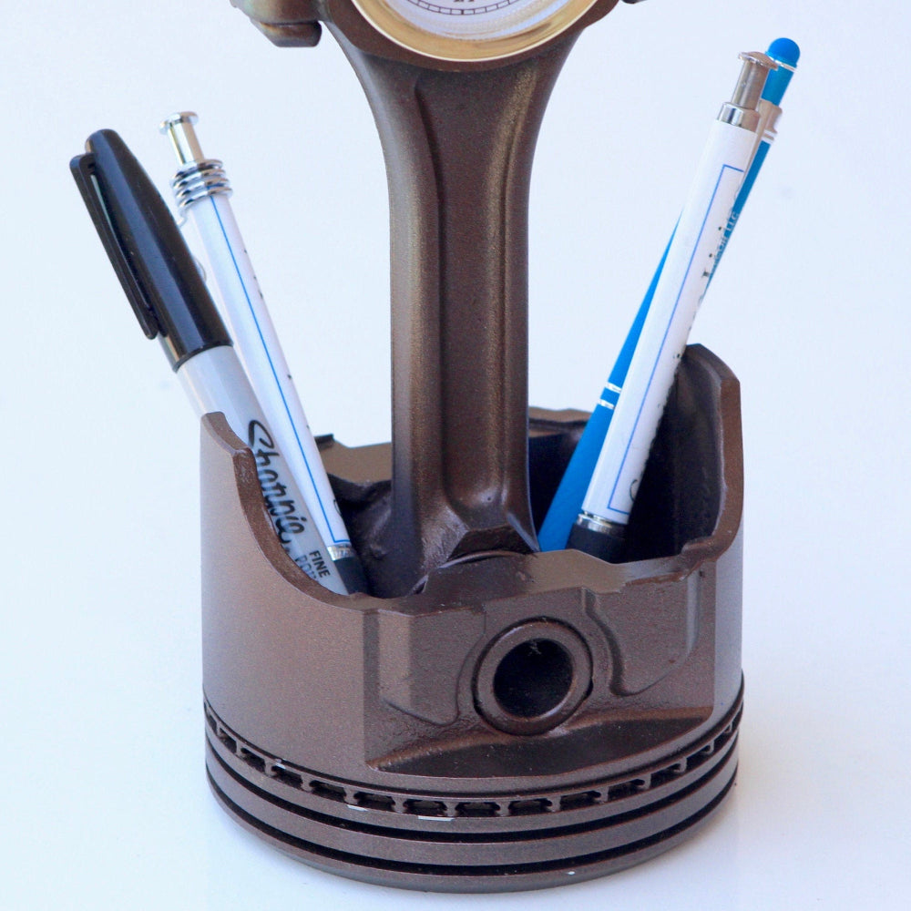 Real piston clock designed for automotive themed workspaces with functional time display and storage.