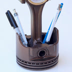 Real piston clock designed for automotive themed workspaces with functional time display and storage.