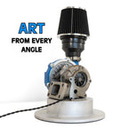 Table lamp built using a real turbocharger and intake, giving it genuine high performance character. Turbocharger on a white background with 'ART FROM EVERY ANGLE' text