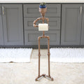 Freestanding toilet paper butler stand made from durable galvanized metal piping.